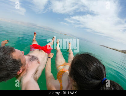 Giovane galleggiante in acqua del mar Morto, Israele Foto Stock