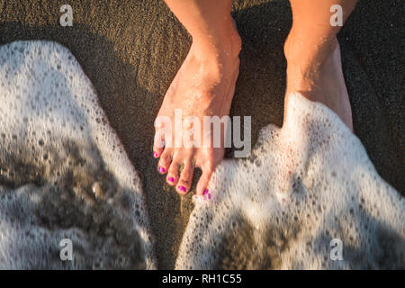 Lavaggio dei piedi dalle onde del mare Foto Stock