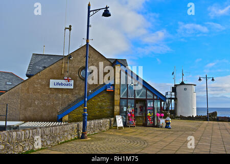 Scialuppa di salvataggio RNLI station e il negozio alla fine del lungomare di Porthcawl. Il vecchio dei piloti della torre di vedetta si trova dietro & è ora una stazione Coastwatch. Foto Stock