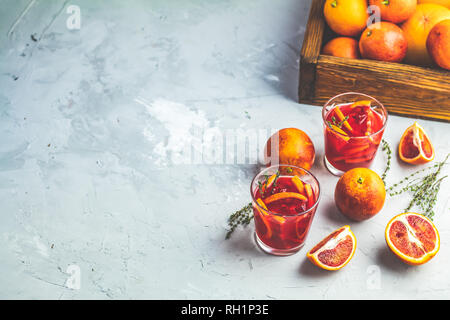 Arancio sanguigno Margarita cocktail con ghiaccio e timo su grigio chiaro sfondo concreto, copia spice, profondità di campo. Foto Stock