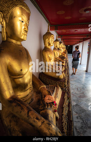 Fila di Golden Statue di Buddha Wat Pho Palace Tailandia Bangkok Foto Stock