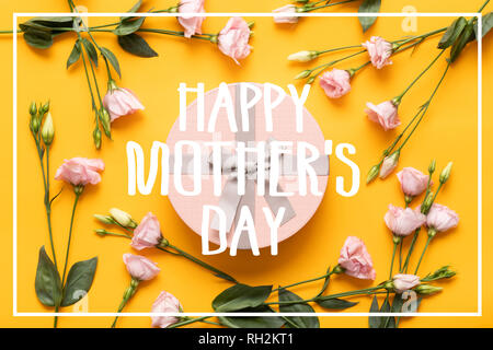 Felice Festa della Mamma sfondo. Di colore giallo brillante e di colore rosa pastello colorato giorno madre dello sfondo. Lay piatto biglietto di auguri con bella confezione regalo e rosa li Foto Stock