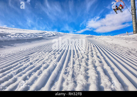 Svuotare il percorso di sci nel comprensorio sciistico dopo il passaggio di camion e persone su sedie di sci. Giornata di sole. Pista da sci in Karakol, Kirghizistan. Foto Stock