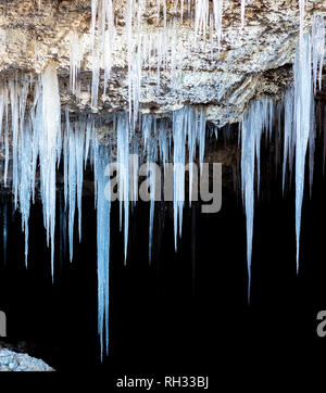 Molti ghiaccioli che pendevano dal soffitto della caverna Foto Stock