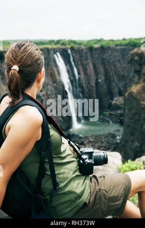 Donna che guarda la cascata Foto Stock