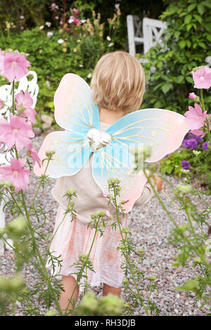 Ragazza indossando ali di fata in giardino Foto Stock