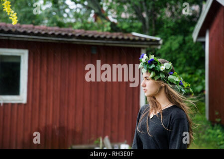 Donna che indossa ghirlanda di fiori Foto Stock