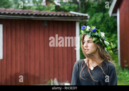 Donna che indossa ghirlanda di fiori Foto Stock