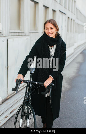 Donna sorridente con noleggio biciclette Foto Stock