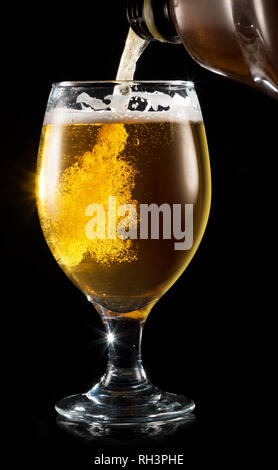 Birra di processo di colata. Il riempimento di una tazza con una birra su sfondo bianco. Foto Stock