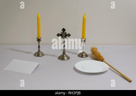 Croce, candele e preparati degli sprinkler prima di sacerdote visitazione. Foto Stock