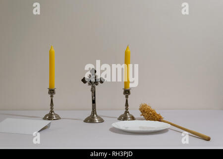 Croce, candele e preparati degli sprinkler prima di sacerdote visitazione. Foto Stock