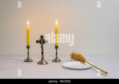 Croce, candele e preparati degli sprinkler prima di sacerdote visitazione. Foto Stock