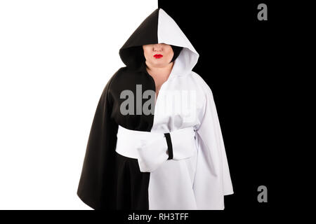 Donna grassa con cappa in splendido nero e abito bianco su nero e sfondo bianco Foto Stock