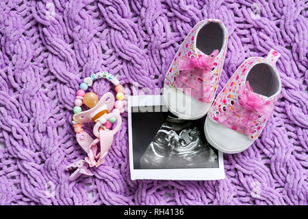 Scarpine blu accanto alla foto del bambino con ultrasuoni a 20 settimane di gravidanza. Il concetto di attesa della baby boy, gravidanza. Un figlio. Messa a fuoco selettiva Foto Stock