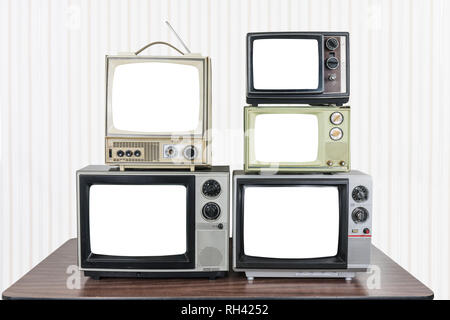 Cinque televisori vintage sul vecchio tavolo in legno con taglio fuori schermate Foto Stock