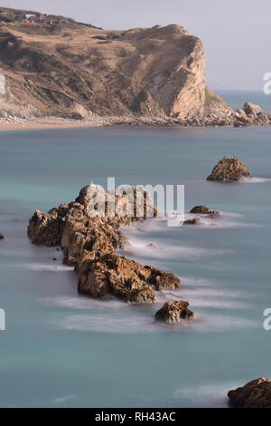 Una lunga esposizione del mare intorno a un ripiano di rocce a Durdel porta in Dorset Foto Stock