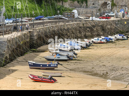 TENBY, Pembrokeshire, Galles - Agosto 2018: piccole barche nel porto in Tenby, West Wales, con la bassa marea con funi linee legato alla parete del porto Foto Stock