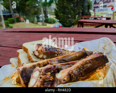 Una piastra di brace costine siede su un tavolo da picnic al di fuori Archibald's Bar B.Q. in Northport, Alabama, Marzo 15, 2014. Foto Stock