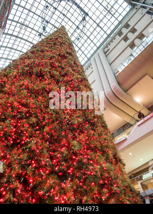 Grande Albero di Natale artificiale all'Eaton Centre: un enorme, perfettamente conica albero decorato con il rosso e bianco luci è un centro di Natale di pezzi in questo affollato centro commerciale di Toronto. Foto Stock