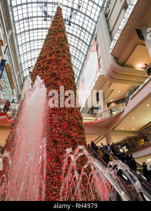 Fountians e un grande albero di Natale artificiale all'Eaton Centre: un enorme, perfettamente conica albero, incorniciato da fountians e decorate con il rosso e bianco luci è un centro di Natale di pezzi in questo affollato centro commerciale di Toronto. Foto Stock