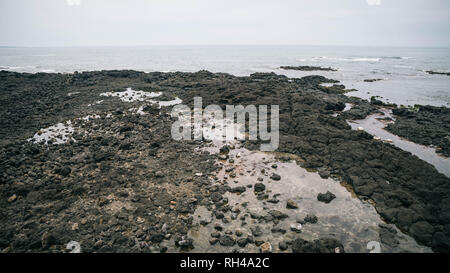 La roccia vulcanica spiagge sulla costa dell'Isola di Jeju Seogwipo area Foto Stock