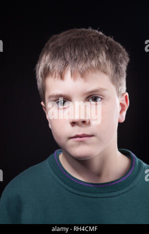 Studio dei colpi di giovane ragazzo con breve marrone capelli, indossando il ponticello verde Foto Stock