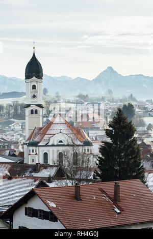 NESSELWANG, Germania - Dicembre 2018: vista la mattina su Nesselwang centro storico con Alpi sullo sfondo. Orientamento verticale. Foto Stock