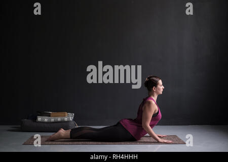 Donna pratica lo yoga, facendo esercizio Cobra, Bhujangasana pongono Foto Stock