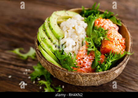 Hawaiian poke ciotola di noce di cocco con il salmone grigliato pesce, riso e avocado. Cibo sano Foto Stock