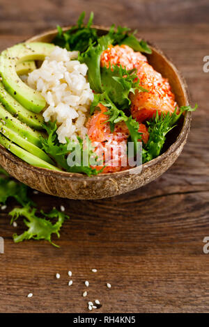 Hawaiian poke ciotola di noce di cocco con il salmone grigliato pesce, riso e avocado. Cibo sano Foto Stock