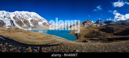 Vista panoramica attraverso Tilicho Lake per la coperta di neve vertice e delle pendenze del Tilicho picco a sunrise Foto Stock