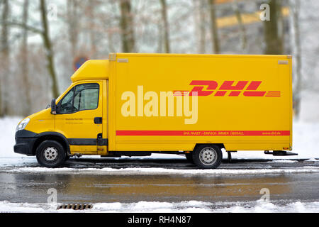 Giallo DHL international e corriere pacchi servizio deliivery carrello nella neve in Germania Foto Stock