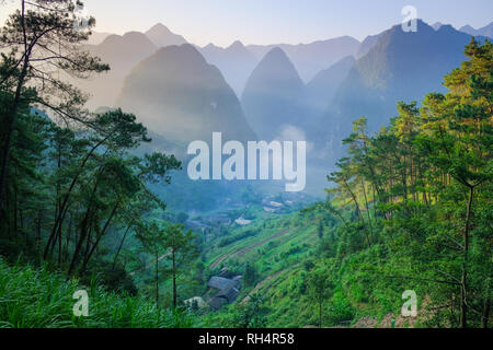 Nord vietnamiti valle con montagne carsiche coperti dalla nebbia in Ha Giang / Dong Van regione. Foto Stock