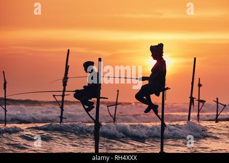 Sagome dei pescatori tradizionali. Stilt tradizionali di pesca vicino a Galle nello Sri Lanka. Foto Stock