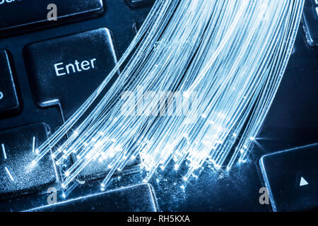 Bundle di fibre ottiche con le luci di estremità giacciono sulla tastiera. Foto Stock