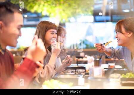 Giovani amici di mangiare hot pot nel ristorante Foto Stock