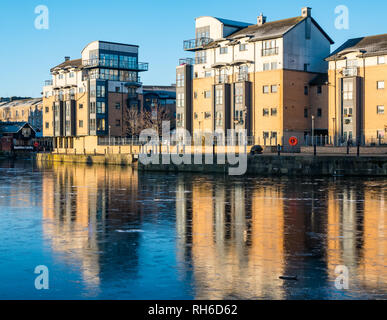 La Riva, Leith, Edimburgo, Scozia, Regno Unito, 1 febbraio 2019. Regno Unito: meteo fenomeno insolito di acqua congelata di Leith. Moderno appartamento edifici riflettono in la superficie ghiacciata del fiume Foto Stock