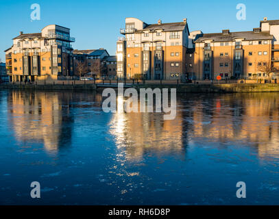 La Riva, Leith, Edimburgo, Scozia, Regno Unito, 1 febbraio 2019. Regno Unito: meteo fenomeno insolito di acqua congelata di Leith. Moderno appartamento edifici riflettono in la superficie ghiacciata del fiume Foto Stock