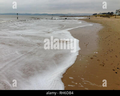 Banchi di sabbia spiaggia, Poole, Dorset, Regno Unito. Il 1 febbraio, 2019. La neve è scesa sul Purbeck Hills nel Dorset, alcuni di cui sulle spiagge. L alta marea brough in alcune belle onde ed era piacevole camminare sulla spiaggia. Suzanne credito McGowan / Alamy Live News Foto Stock