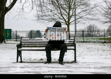 Londra, UK 1 Feb 2019 - Un uomo seduto su una panchina coperta di neve è visto leggendo una copia di oggi del metro in un North London park dopo una notte di nevicata nella capitale. Credito: Dinendra Haria/Alamy Live News Foto Stock