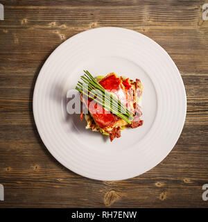 Lay piatto di formaggio alla griglia con lattuga su sfondo di legno Foto Stock