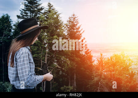 Elegante e attraente bella donna con vintage analogici telecamera cinematografica rende la foto all'aperto al tramonto del tempo, crea il contenuto per i social media channel Foto Stock