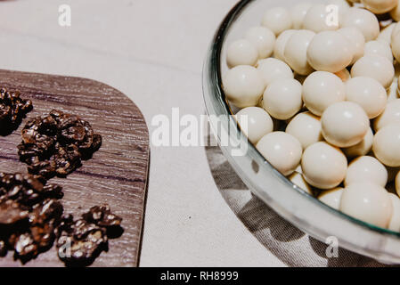 Da sopra insieme di caramelle in bianco e nero di dolci sul piatto di portata e di bordo su sfondo bianco Foto Stock