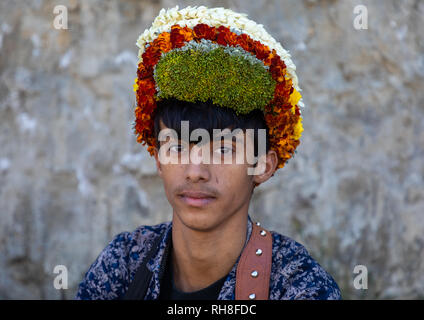 Ritratto di un fiore giovane uomo che indossa una corona di fiori sulla testa, Jizan Provincia, Addayer, Arabia Saudita Foto Stock