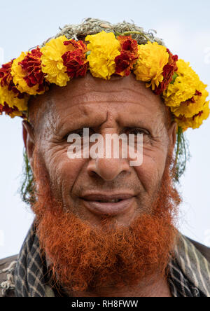 Ritratto di un fiore uomo con una barba rossa che indossa una corona di fiori sulla testa, Jizan Provincia, Addayer, Arabia Saudita Foto Stock