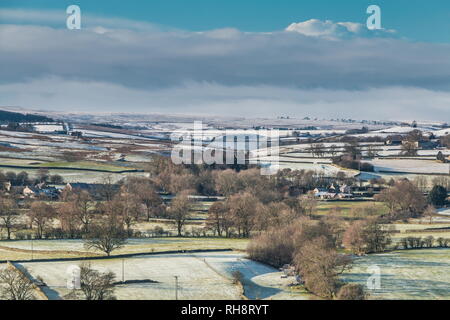 North Pennines AONB paesaggio, vista dal fischio roccioso sopra Teesdale in Lunedale con coperta di neve colline in lontananza nel luminoso sole invernale Foto Stock