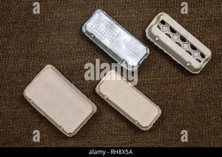 Vista superiore del cartone quattro contenitori per uova su uno sfondo di colore marrone. Foto Stock