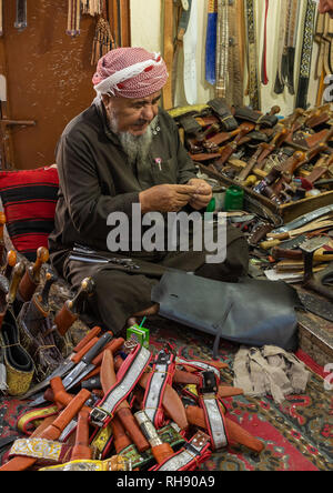 Un uomo in Arabia si prepara un tradizionale janbiya pugnale per la vendita all'interno del suo negozio Najran provincia Najran, Arabia Saudita Foto Stock