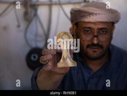 Un uomo in Arabia si prepara un tradizionale janbiya pugnale per la vendita all'interno del suo negozio Najran provincia Najran, Arabia Saudita Foto Stock